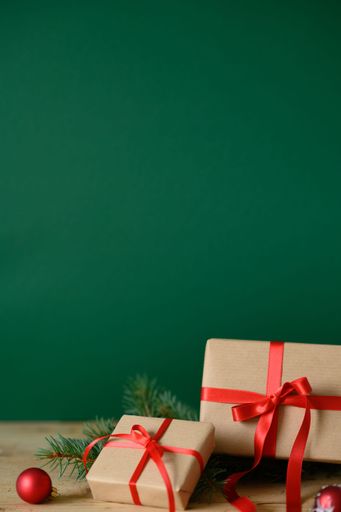 A vertical shot of Christmas presents against a green background