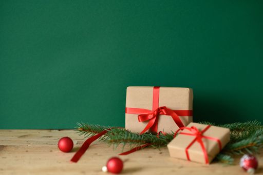 A table with Christmas presents against a green background