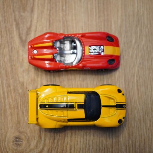 A top view of the Lotus Sport Elise and Glory Chaser Mattel Hot Wheels toy cars on a wooden surface