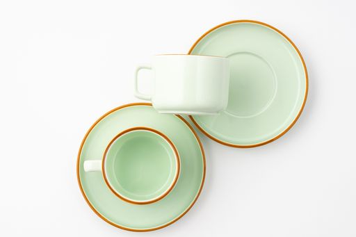 A flat lay of a set of ceramic kitchen utensils such as cups and plates on white background