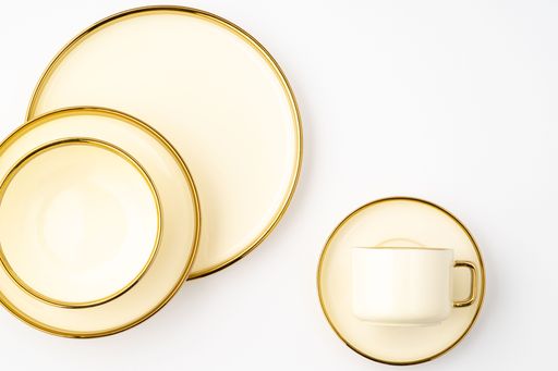 A top-view shot of golden luxury ceramic kitchen utensils on a white background.