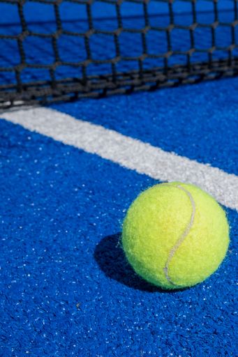 ball near the net of a paddle tennis court