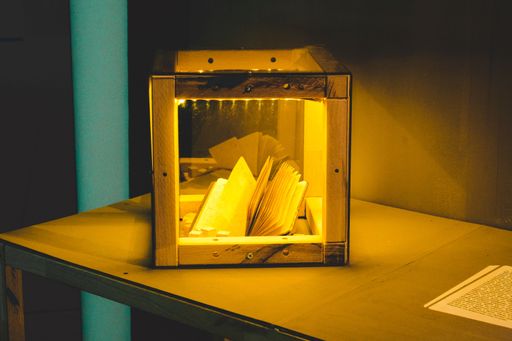 A close-up view  of a pocketbook in the wooden glass box over a table