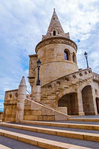 A vertical low-angle shot of the tower of Fisherman's bastion in Budapest, Hungary