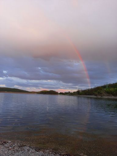 Beautiful lake and rainbow in the cloudy sky