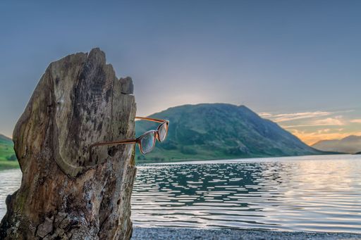 A beautiful shot of a cliff wearing glasses near a sea during the day