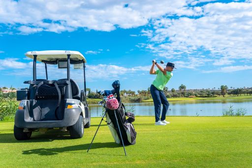 A scenic view of a Caucasian man playing a golf match on a bright sunny day