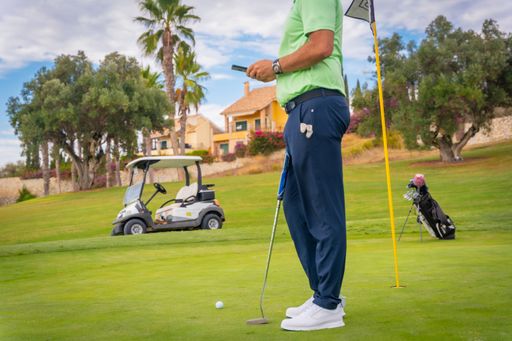 A professional male golf player playing golf at golf course by a lake