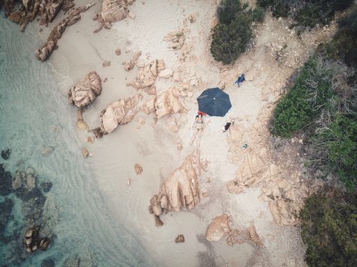 An aerial shot of a female lying on a paradise beach