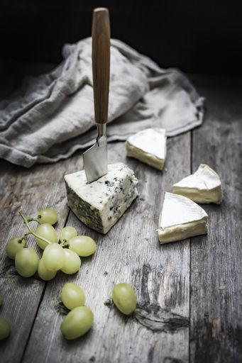 A vertical shot of delicious brie cheese on a wooden deck - perfect for a food blog