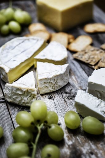 A vertical shot of delicious brie cheese on a wooden deck - perfect for a food blog