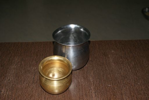A high angle shot of two silver and golden iron jars on a wooden surface