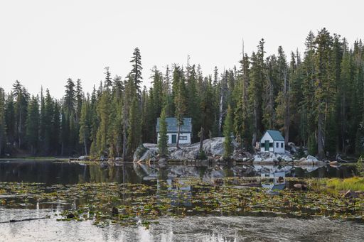 A private cabin reflects on the water at Mosquito Lakes, a high elevation alpine lake along Ebbetts Pass.