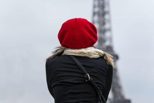 A back view of a young female in a red hat with Eiffel tower on the background