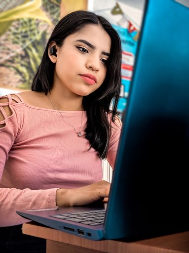 A vertical shot of a female working with a laptop