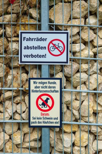 Typical warning signs with prohibitions on a stone wall