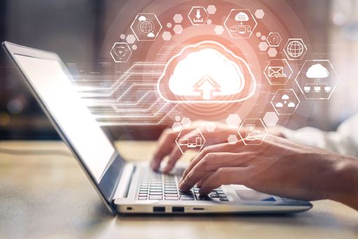 A person typing on a laptop with a 3D rendering of cloud computing technology and online data