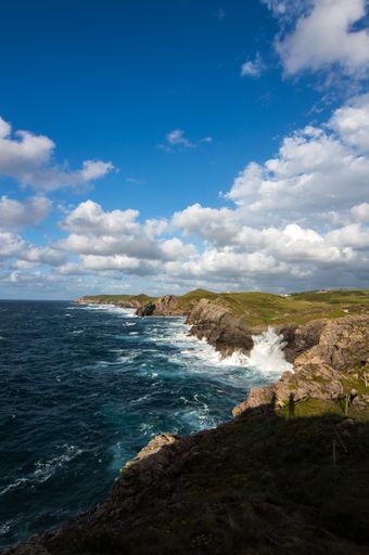 A beautiful scenery of rocky cliffs by the sea under a cloudy sky