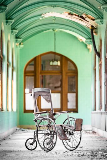 A vertical shot of a broken metallic wheelchair