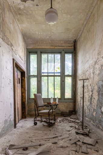A vertical shot of a wheelchair in a dilapidated home