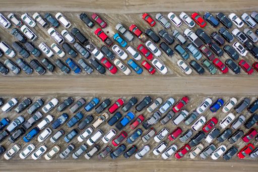 An aerial top view of cars parked densely in a parking lot