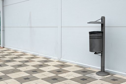 The trash can on the paving slabs on the street