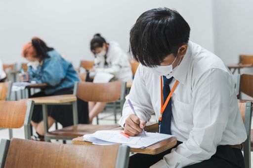 College students concentratively writing on final examination papers in a classroom
