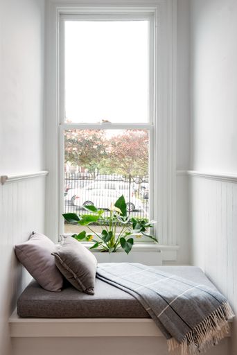 A vertical shot of a cozy bed in a room with a balcony