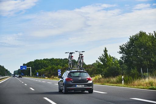 Freeway 11, Germany - August 30, 2020: Car on the freeway 11 with a bike carrier attached on the car roof and bicycles mounted on it.