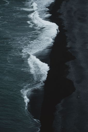 A vertical aerial view of the Iconic Black Beach Of Iceland