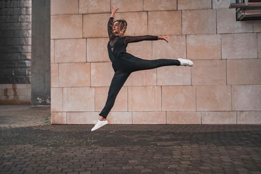 A young girl doing a gymnastic jump on the street - urban contemporary dance concept