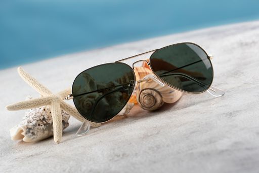 A closeup shot of sunglasses on sea shells in a marine environment