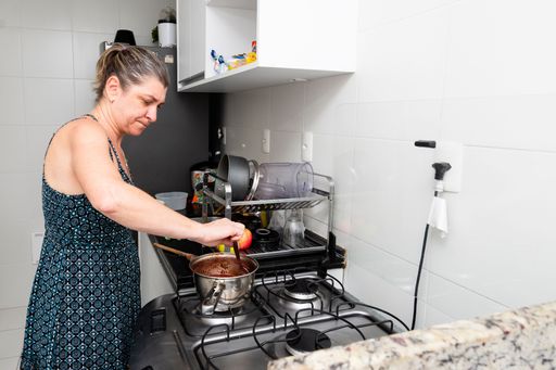 Young woman preparing cheesecake in the kitchen with various ingredients. Family gastronomy. Salvador, Bahia, Brazil