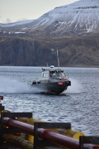A vertical shot of a small boat sailing in the Bering sea of the Aleutian island, Alaska