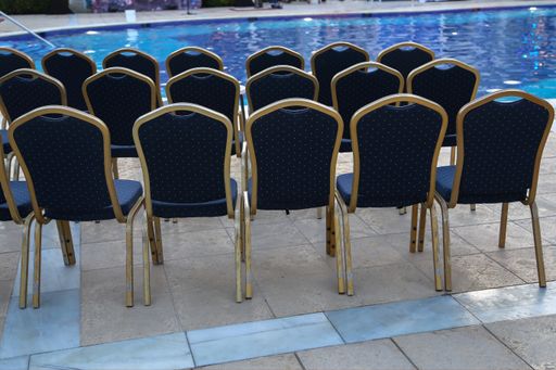 A high angle shot of empty chairs row near a pool