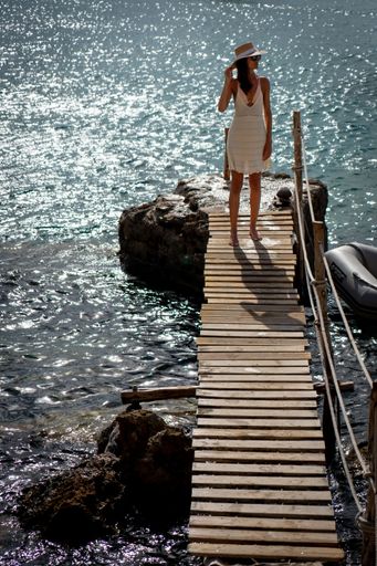 An attractive Caucasian female standing on the pier over the sea