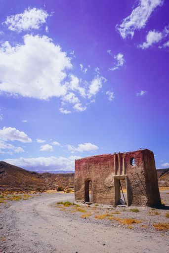 A vertical shot of an abandoned rural area in a dry field during daylight