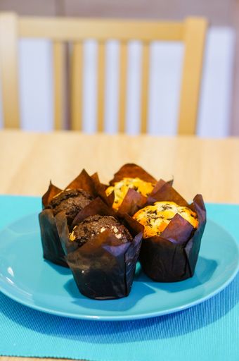 A vertical shot of fresh chocolate and vanilla muffins on a plate