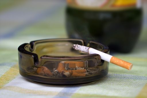 A closeup macro shot of a burning cigarette on an ashtray - concept of smoking