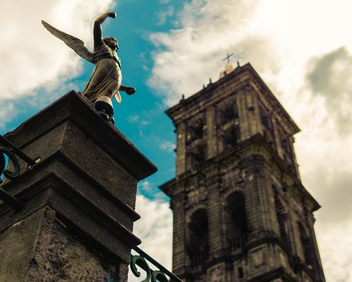A low angle selective focus of an angel statue on a post of Puebla Cathedral in Puebla, Mexico