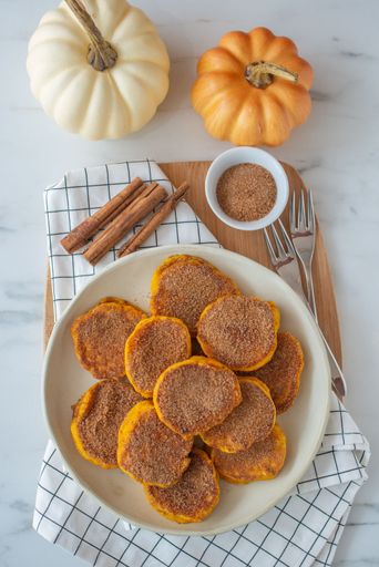A vertical top view of a healthy autumnal breakfast of sweet homemade pumpkin pancakes.