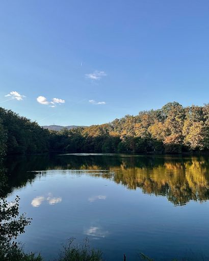 A landscape shot of a reflective lake in Maksimir park under the clear sky in Zagreb
