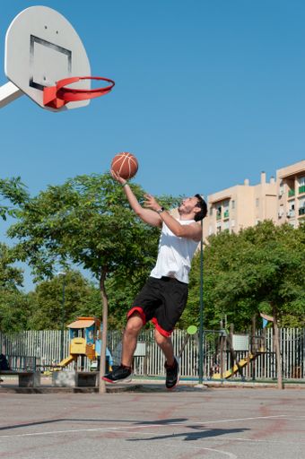 A vertical shot of a person playing basketball