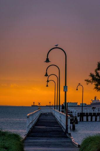 A view of cozy pier at vibrant sunset over calm sea