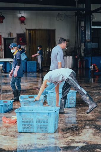 Sekinchan, Malaysia - Oct 6, 2022 Fishermen sorting out the fish catch in containers at the dock.