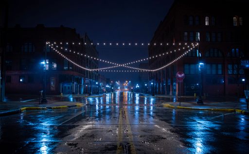 A wet street at night with lights in Sioux City