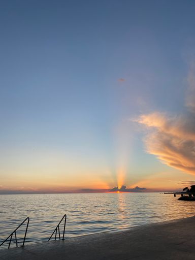 A vertical shot of a beautiful sunset seen on the horizon of a beach