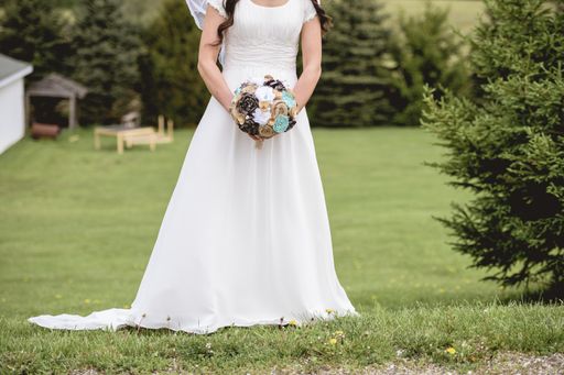 A closeup shot of a bride holding a bouquet of flowers with a blurred background
