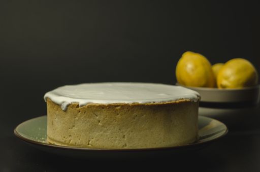 A portion of lemon tart with meringue and lemons decoration on a  black background
