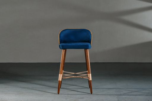 A blue dining room chair in a studio with gray walls